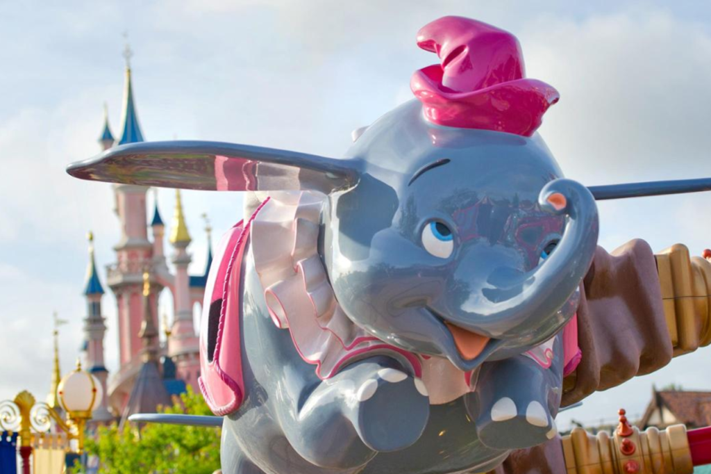 Dumbo the Flying Elephant ride at Disneyland Paris with Sleeping Beauty Castle in the background, a perfect attraction for young children.