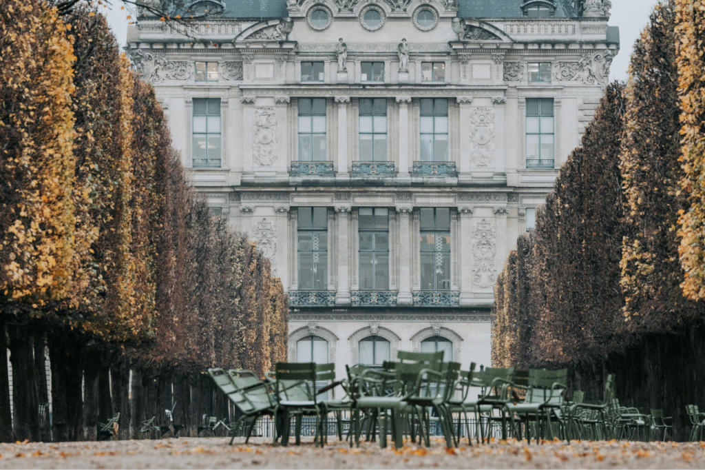 When Is the Best Time to Visit Paris? Autumn in Tuileries Garden with golden leaves and a view of historic Parisian architecture